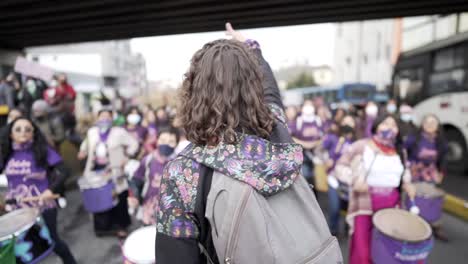 Una-Mujer-Lidera-Un-Grupo-De-Mujeres-Vestidas-De-Púrpura-Que-Tocan-Tambores-Mientras-Marchan-Durante-La-Protesta-En-El-Día-Internacional-De-La-Mujer-En-Quito,-Ecuador.