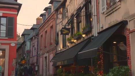 Couple-Walking-In-The-Narrow-Street-Of-Honfleur-Old-Town-During-Sunset-In-France