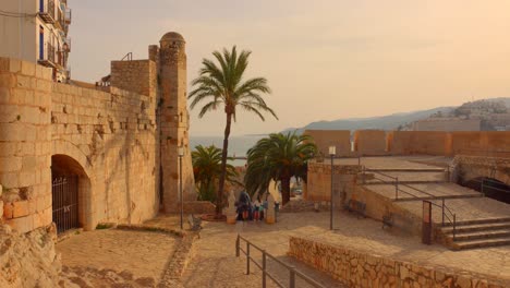 Touristen-Betreten-Den-Ausgang-Der-Burg-Peniscola-Bei-Sonnenuntergang-In-Castellon,-Spanien