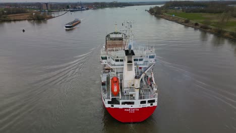 Empty-container-ship-"Marjatta"-navigating-through-the-city-canal-of-Zwijndrecht-aerial-view