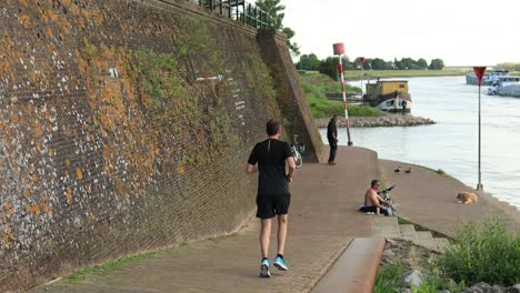 Atleta-Entrenamiento-De-Resistencia-Correr-Ejercicio-Al-Aire-Libre-Concepto-De-Entrenamiento-Deportivo-En-La-Orilla-Del-Río-A-Lo-Largo-De-La-Histórica-Muralla-De-Defensa-De-La-Ciudad