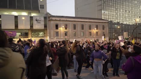 Women-are-jumping-and-singing-while-holding-up-sings-of-protest-during-the-International-Women's-day-in-Quito,-Ecuador