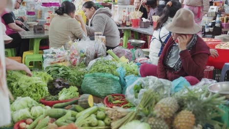 Local-vendors-sells-fresh-fruits-and-vegetables,-at-busy-and-colorful-Con-Market-in-Danang,-Vietnam