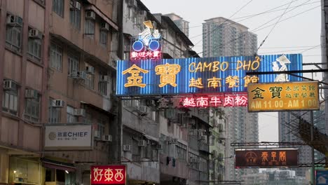 A-restaurant-business-blue-neon-sign-hangs-from-a-facade-of-a-residential-building-in-Hong-Kong