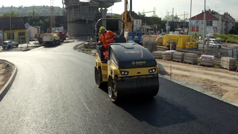 Trabajador-Operando-Máquina-Apisonadora-En-La-Carretera-De-La-Ciudad-Recién-Asfaltada