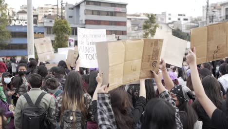 During-the-International-Women's-Day,-women-are-marching-in-Quito-Ecuador-while-holding-signs-with-protest-messages