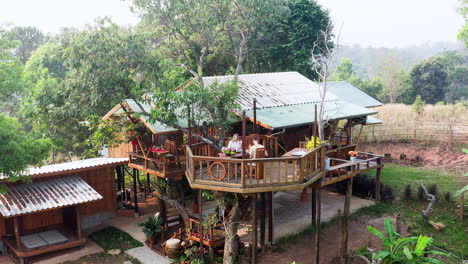 Young-couple-having-breakfast-on-wooden-treehouse-terrace-in-Thailand