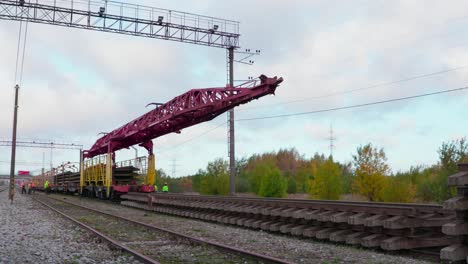 railway-railroad-construction-crane-unloading-new-train-track,-wide-shot,-static