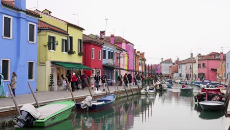 Lebhafte,-Farbenfrohe-Burano-Straßengebäude-Und-Boote-Auf-Und-Ab-Des-Kanals