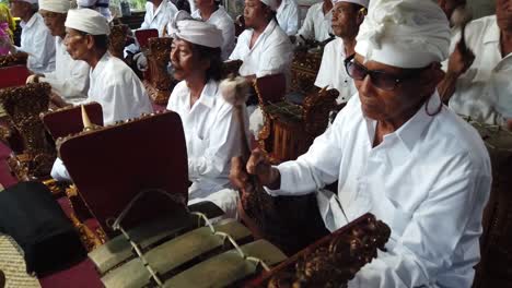 Un-Grupo-De-Música-Gamelan-Toca-Una-Actuación-Religiosa-En-La-Ceremonia-Del-Templo-En-Gianyar-Bali-Indonesia,-Samuan-Tiga-Cerca-De-Un-Colorido-Festival