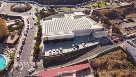 Lidl-chain-store-in-Tenerife-island-surrounded-by-small-town,-aerial-view