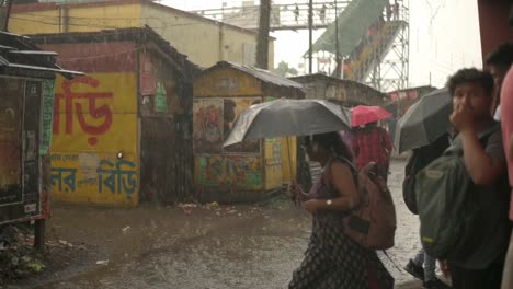 Menschen-Stecken-Im-Regen-Mit-Offenen-Regenschirmen-Fest-Und-Versuchen-Nach-Hause-Zurückzukehren,-Monsunzeit,-Zeitlupenaufnahme-Von-Regentropfen