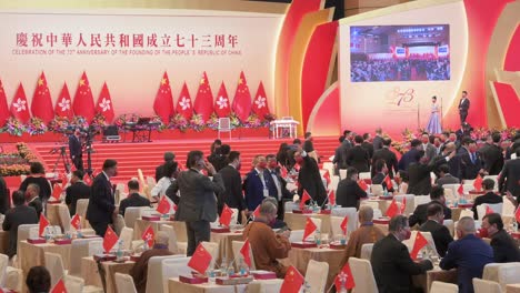 Government-officials-and-Pro-China-guests-are-seen-at-the-ceremony-celebrating-China's-National-Day-on-October-1st-as-Hong-Kong-and-Chinese-flags-hang-from-the-wall-in-the-background