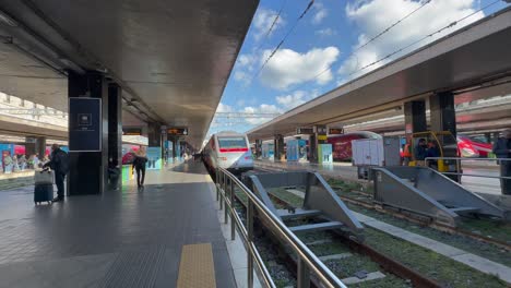 Modern-trains-along-platforms-of-Termini-station-with-people-waiting,-Rome-in-Italy