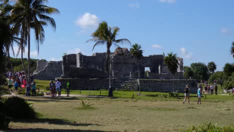 Tourists-visiting-The-Great-Platform-and-The-Palace-at-Tulum-archeological-site,-Quintana-Roo,-Mexico