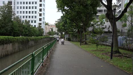 Vista-De-Un-Anciano-Que-Utiliza-Scooters-Eléctricos-PMA-Para-Moverse-De-Forma-Cómoda-Y-Segura-En-Whampoa-Park-Connector,-Singapur