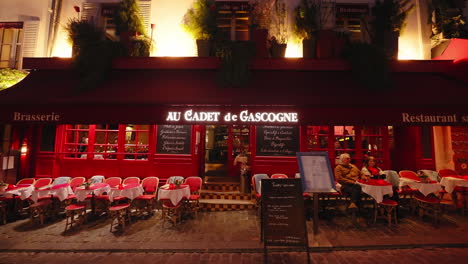 Kleine-Tische-Vor-Einem-Brasserie-Kaffeerestaurant-In-Paris-In-Der-Nähe-Von-Montmartre,-Nachts