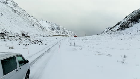 Campervan-travelling-over-snow-covered-terrain-in-arctic-Norway,-Lofoten