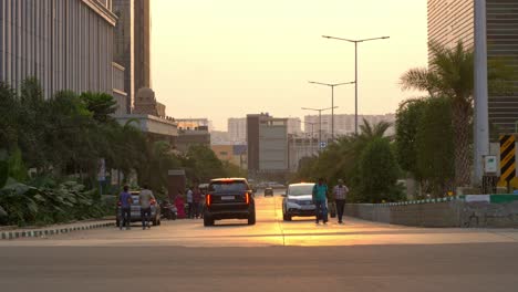 Brightly-lit-newly-built-Highrise-residential-buildings-in-HITECH-city-with-car-driving-on-street-in-the-evening,-Hyderabad