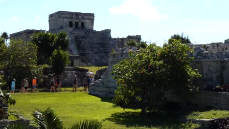 Groups-of-tourists-visiting-The-Castle-mayan-ruins-at-Tulum-archeological-site,-Quintana-Roo,-Mexico