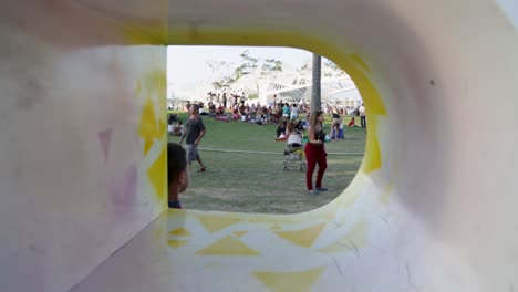 Mother-with-sun-glasses-interacting-and-kissing-child-who-is-playing-at-Praca-Maua,-in-Rio-de-Janeiro,-Brazil