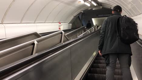 Commuter-in-Paddington-Station-using-the-escalator-in-the-London-Underground,-London,-UK