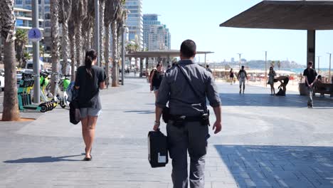 Peoples-walking-in-the-boardwalk-at-Hukok-Beach,-Tel-Aviv,-Israel