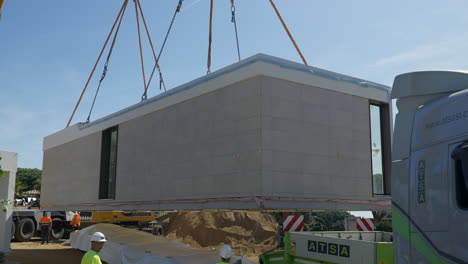 Close-up-of-prefabricated-house-module-being-lifted-from-truck