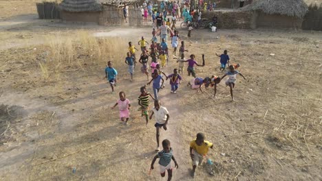 Niños-Locales-Felices-Persiguiendo-Un-Dron-En-Un-Pequeño-Pueblo-De-Gambia