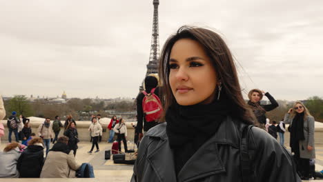 Pretty-young-brunette-tourist-girl-posing-in-front-of-the-Eiffel-tower