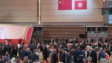 Government-officials-and-guests-are-seen-at-the-ceremony-celebrating-China's-National-Day-on-October-1st-as-Hong-Kong-and-Chinese-flags-hang-from-the-wall-in-the-background