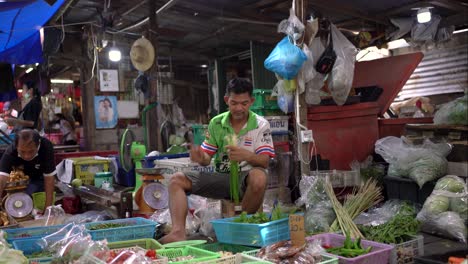 Verkäufer-Von-Frischgemüseständen-Verpacken-Und-Wiegen-Gemüse-Auf-Dem-Maeklong-Eisenbahnmarkt,-Einer-Einzigartigen-Und-Faszinierenden-Attraktion-In-Der-Provinz-Samut-Songkhram,-Südwesten-Von-Bangkok,-Thailand
