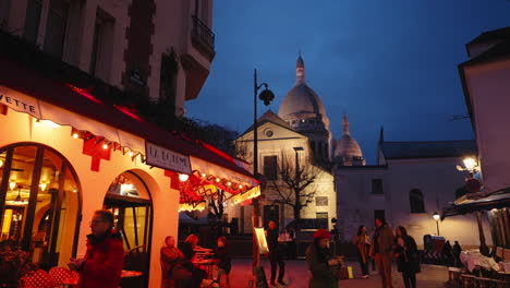 Cityscape-of-a-brasserie-coffee-restaurant-and-a-white-church,-in-Paris-near-Montmartre,-at-night
