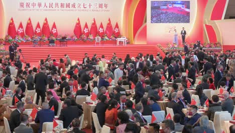 Government-officials-and-Pro-China-guests-are-seen-at-the-ceremony-celebrating-China's-National-Day-on-October-1st-as-Hong-Kong-and-Chinese-flags-hang-from-the-wall-in-the-background
