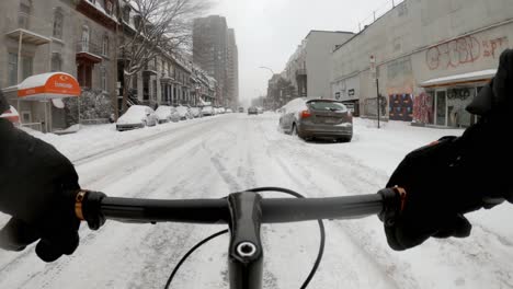 POV-Handlebar-View-Cycling-Through-Snow-Covered-Road-In-Downtown-Neighbourhood-In-Montreal