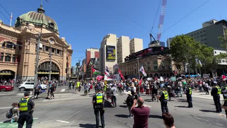 Protesters-chanting-in-Melbourne-Australia-stopping-all-traffic,-police-watching-on-as-the-protesters-stop-all-traffic