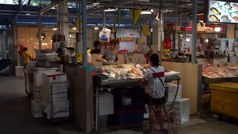 Fish-vendors-prepare-and-pack-fresh-fish-for-the-customer-in-Whampoa-Wet-Market,-Singapore