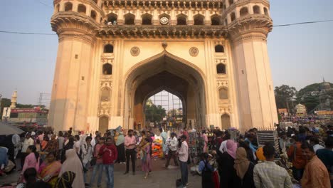 Tilt-down-shot-of-Charminar-on-Saturday-crowded-with-tourists-and-locals-across-the-street-market,-Hyderabad,-India