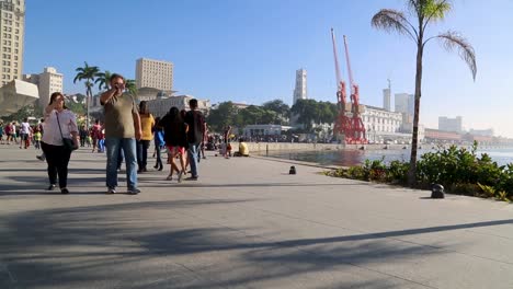 People-walking-around-at-Praca-Maua,-at-sunset,-in-the-center-of-Rio-de-Janeiro,-Brazil
