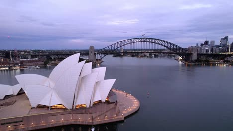 Sydney-Opera-House,-Harbour-Bridge-Am-Abend,-Malerischer-Vorwärtsflug