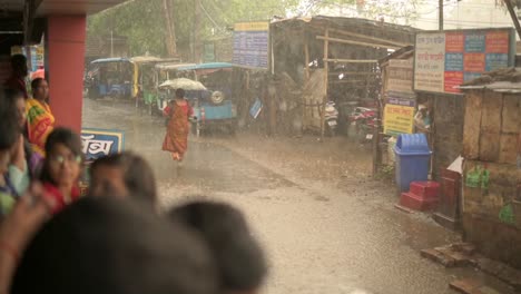 Gente-Atrapada-Bajo-La-Lluvia,-Mujer-Solitaria-Caminando-Bajo-La-Lluvia-Con-Paraguas,-Temporada-De-Monzones-De-Mujer,-Toma-En-Cámara-Lenta-De-Gotas-De-Lluvia