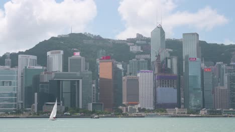Ein-Segelboot-Fährt-Durch-Den-Hafen-Von-Victoria-Vor-Der-Skyline-Von-Hongkong