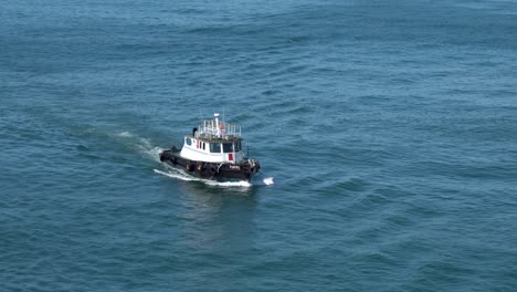 Tugboat-following-ferry-ship-in-the-Sea-of-Cortez-leaving-a-wake-at-medium-speed,-Locked-shot