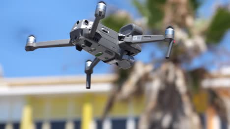 Drone-with-camera-flying-in-the-air,-close-up-with-blurred-background