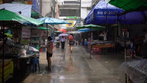 Point-of-view-of-a-lady-with-coloured-hair-trying-to-run-to-a-nearby-shelter-towards-the-main-street-on-a-sudden-rain-in-Silom,-Bangkok,-Thailand