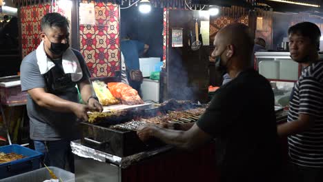 Los-Vendedores-De-Satay-Están-Ocupados-Sesgando-Satay-En-Lau-Pa-Sat,-Singapur