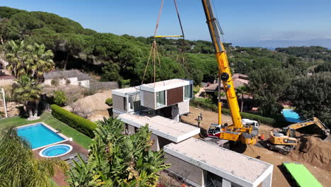 Work-in-progress-with-crane-during-assembly-of-modern-modular-luxury-house