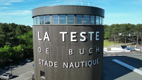 Freediving-tower-with-window-vents-up-top-at-aquatic-pool-facility,-Aerial-pedestal-rising-shot