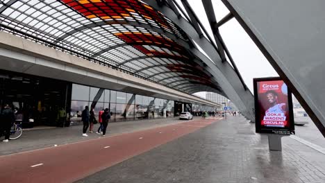 Ein-Stark-Befahrener-Fahrradweg-Vor-Dem-Amsterdamer-Hauptbahnhof,-Während-Die-Menschen-Ihren-Tag-Mit-Dem-Fahrrad-In-Der-Geschäftigen-Stadt-Amsterdam,-Niederlande,-Verbringen