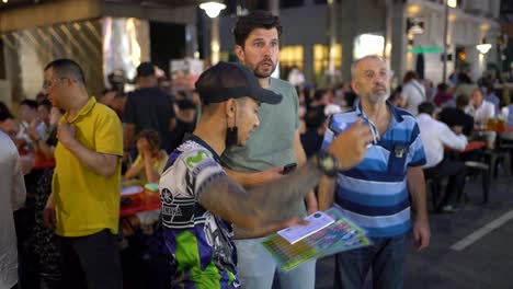 Satay-vendors-taking-orders-and-handing-over-the-food-buzzer-to-the-customers-in-the-middle-of-a-bustling-food-market-at-Lau-Pa-Sat,-Singapore